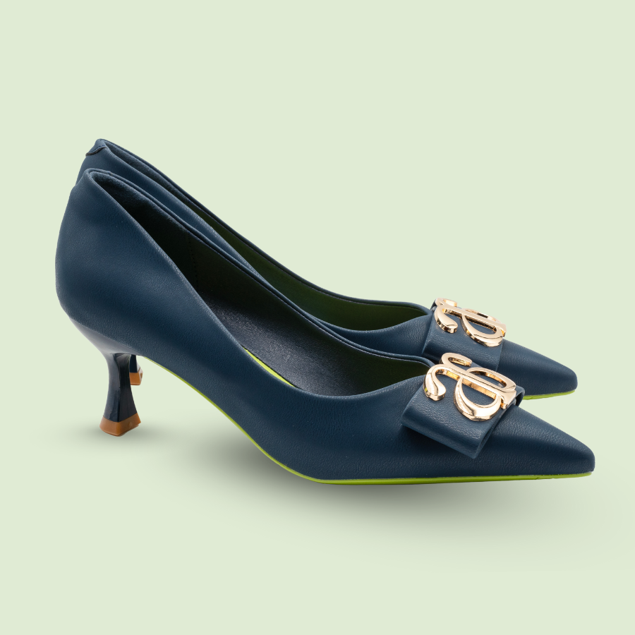 Dark blue Eco Glam Heels with 6.5 cm heel, made from vegan apple peel leather, featuring a pointed toe and decorative gold emblem.
